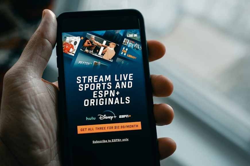 Phone screen showing mobile plans with streaming bundles for live sports, Disney+, Hulu, and ESPN+.