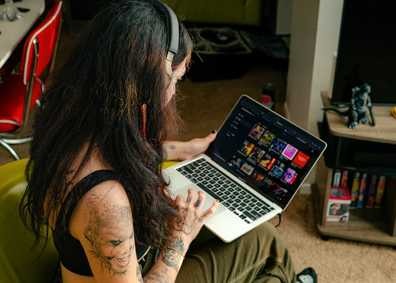 Person browsing streaming options on a laptop while finding the cheapest way to watch streaming.