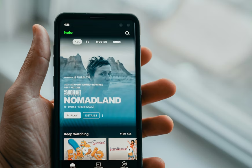 Phone displaying a streaming app, showing how telecom plans with free streaming can affect monthly costs.
