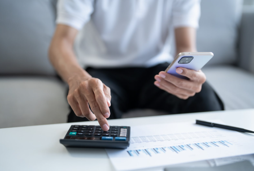Calculator and phone used to review the yearly cost of streaming services.